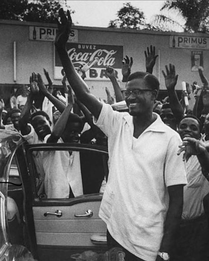 Patrice Emery Lumumba with his arm raised.